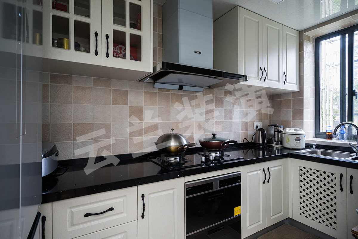 廚房間采用淡雅的白色為主色調，以展示出浪漫、舒適的生活。白色門板讓整體看上去大氣簡約，黑色的石英石臺面耐臟抗污，還有黑色的拉手，一套黑白配永遠也不會過時。加上面磚錯落有序的色彩，給我們展示了廚房靈動的生活氣息。
