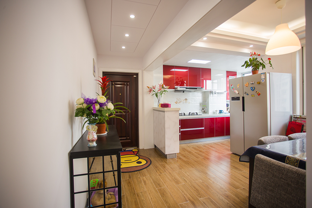 廚房采用紅色系的精鋼板系列門板，加上白色的墻面磚，使得空間得以延伸，看上去顯得更寬敞
