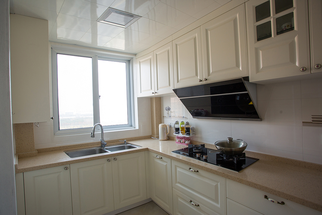 廚房空間較大，墻面白色墻磚，干凈明亮，暖白色的廚柜搭配米黃色的臺面，干凈而舒適，讓男主人也有了愛上燒飯的理由。
