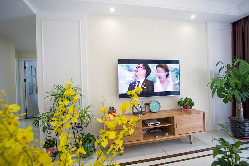 客廳的背景墻采用了護墻板作裝飾，為極簡的背景墻增添了幾分神秘與現(xiàn)代感，深色的家具低調(diào)奢華