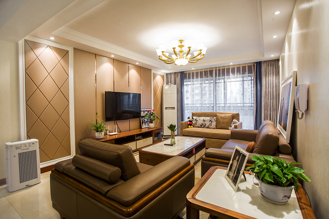 客廳整體風格采用硬包和素色墻紙的搭配，地面采用大理石的拼花方式，在顏色上做了統一，配上精致美式燈和深淺相間窗簾裝飾，配以重色沙發，使整個客廳華而不炫，彰顯業主的獨特品味。
