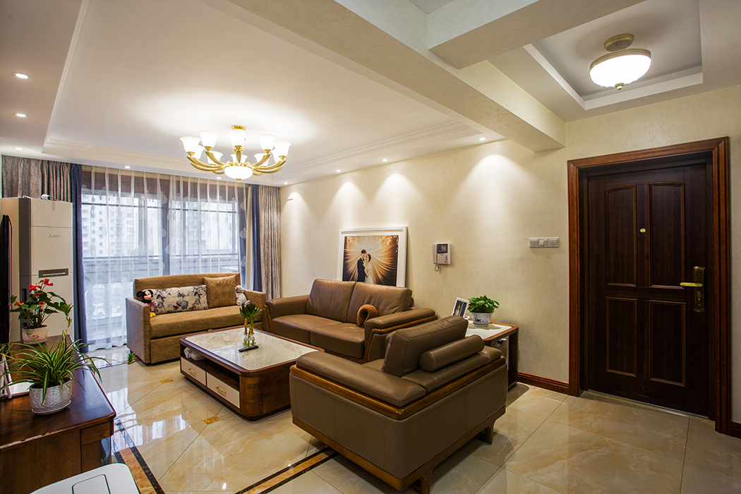 客廳的沙發背景采用了素色墻紙，彰顯結婚照的獨特，吊頂采用簡單修飾，空間全部留給層高，得以視覺增加。
