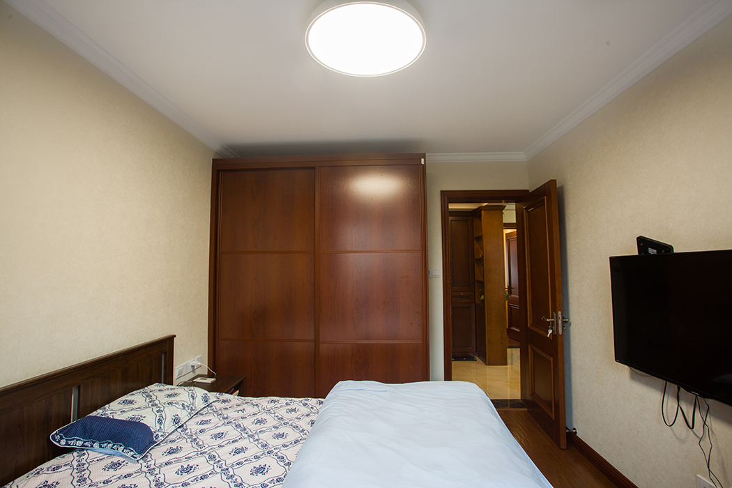 主臥采用深色家具，與深色地板的呼應，讓整個空間得到放大，精致的床頭背景，彰顯業主對于穩重生活的釋然，穩而不俗，淺而不飄。
