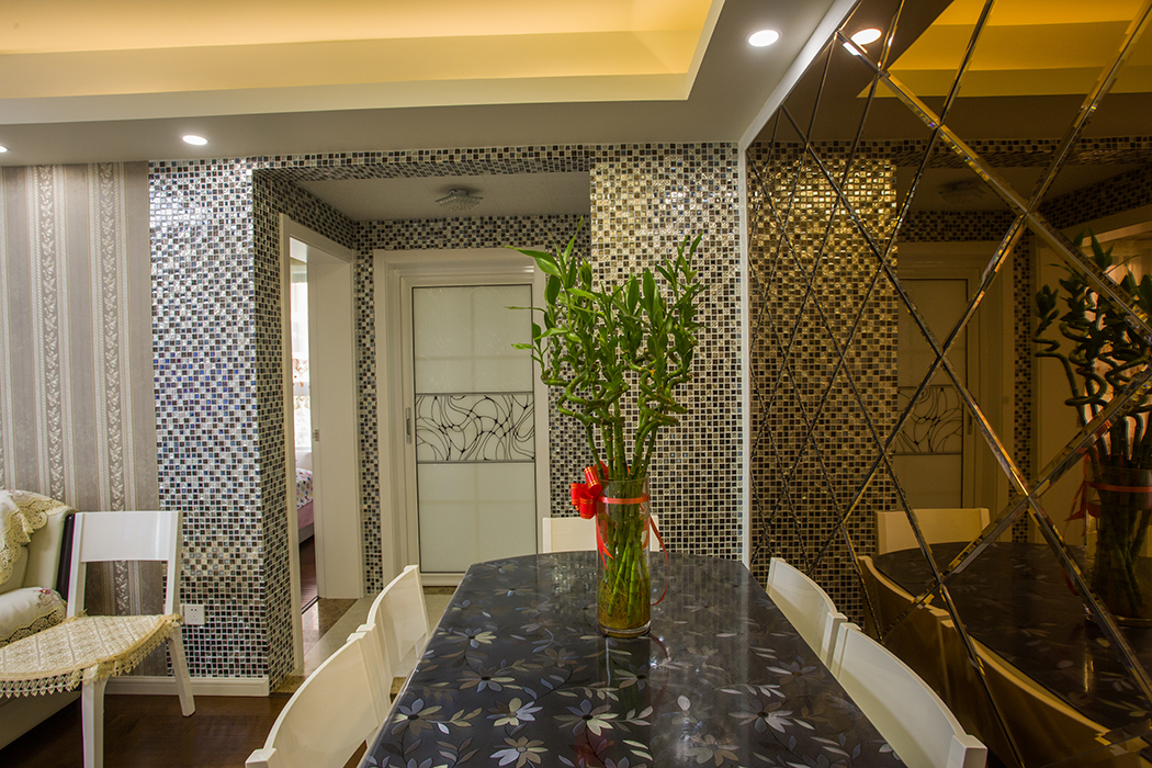 現代簡約風格餐廳裝修中，其木質的餐桌椅，給人一種賞心悅目的真實質感、溫暖的觸感以及最純粹的視覺觀。充滿紅色調點綴的原桌上放上一瓶綠色植物，預示著溫暖中孕育的生命，在春天的季節里茁壯成長。
