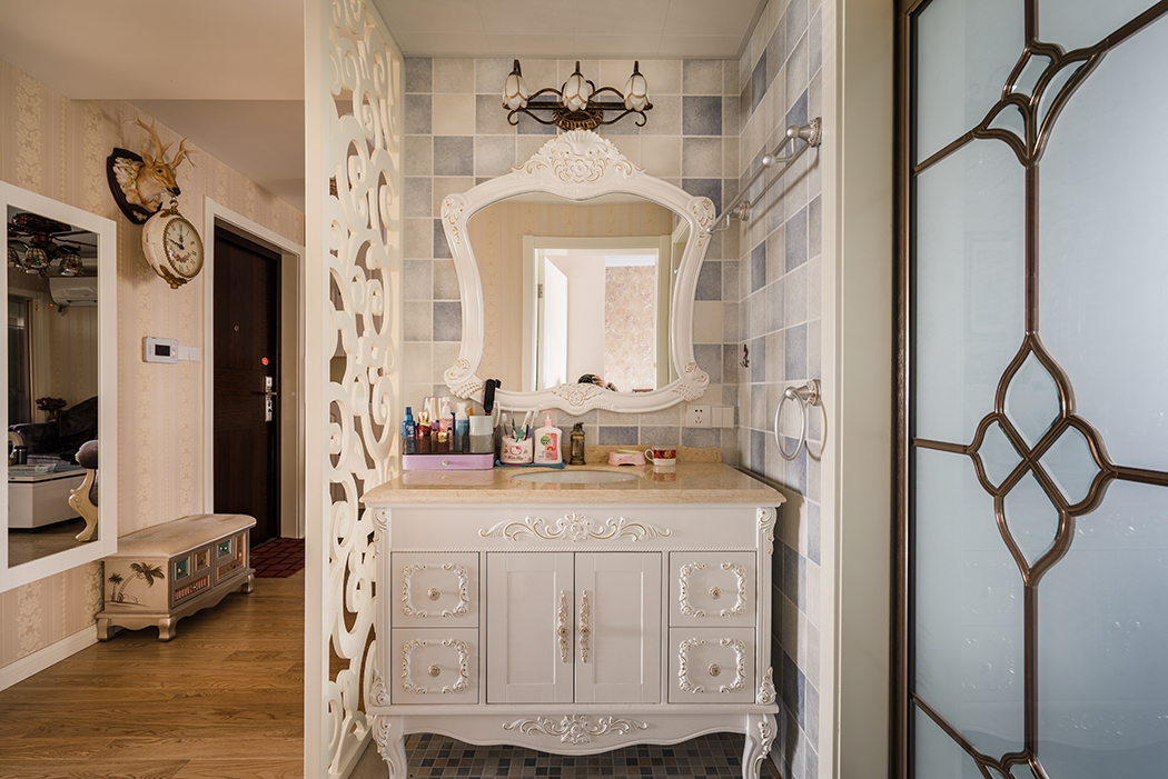 進門的干區處理，配上歐式的漏空花格隔斷，把原本不大的衛生間拓展的實用而且美觀，歐式臺盆柜和古典的鏡前燈，更突顯出主人的品味。

