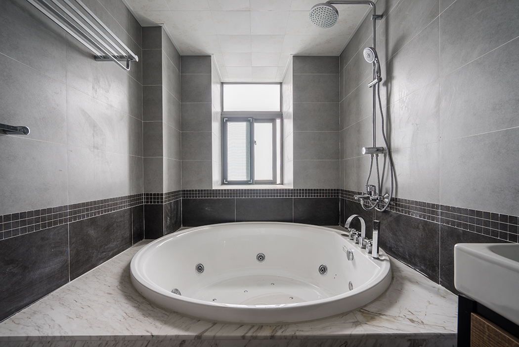 衛(wèi)生間主人需求的大型沖浪浴缸，爵士白的大理石，白色的潔具，和黑灰的墻地磚使空間獨(dú)顯大氣，更滿足了功能需求。
