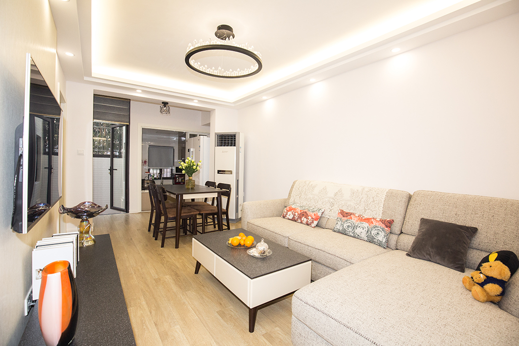 客廳的位置原格局是一個朝南帶院子的房間，因為整體格局沒有客廳一區域，所以改為客廳。整體風格采用原木色地板，白色的涂料看起來更明亮，布藝沙發舒適溫暖。
