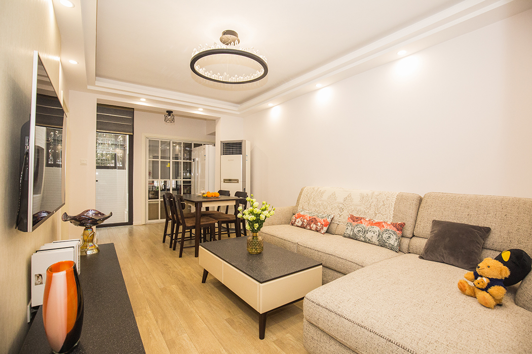 客廳的位置原格局是一個朝南帶院子的房間，因為整體格局沒有客廳一區域，所以改為客廳。整體風格采用原木色地板，白色的涂料看起來更明亮，布藝沙發舒適溫暖。
