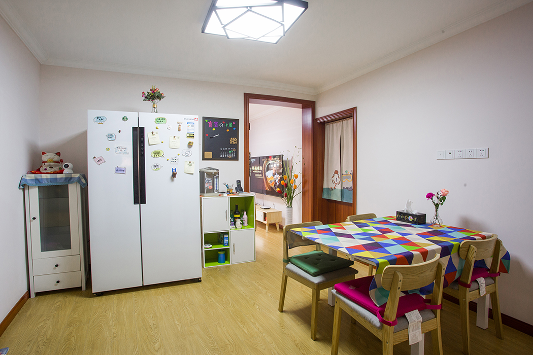 潔凈大方的餐廳空間，冰箱邊上的餐邊柜設計解決了收納難題，白色的雙開冰箱，北歐原木風格的餐桌加上亮色臺布削弱了中性色調帶來的距離感，烘托出溫暖親近的居家氛圍，打造別致的用餐環境。
