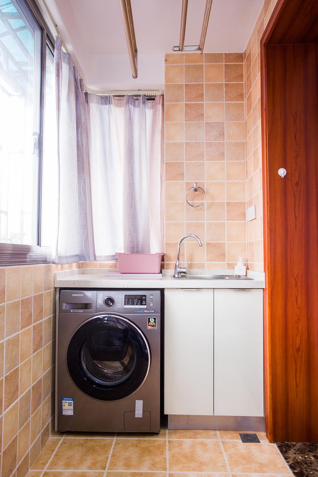 空間從色彩到材質到家具的選擇，盡顯簡約與舒適氣息。整個空間以亮色為主色調，現代的硬朗線條和咖北歐家具的組合，有種現代線條感。客廳亮色絨面沙發與粉紅靠墊、原木邊柜組合增添幾分歡快與質感。
