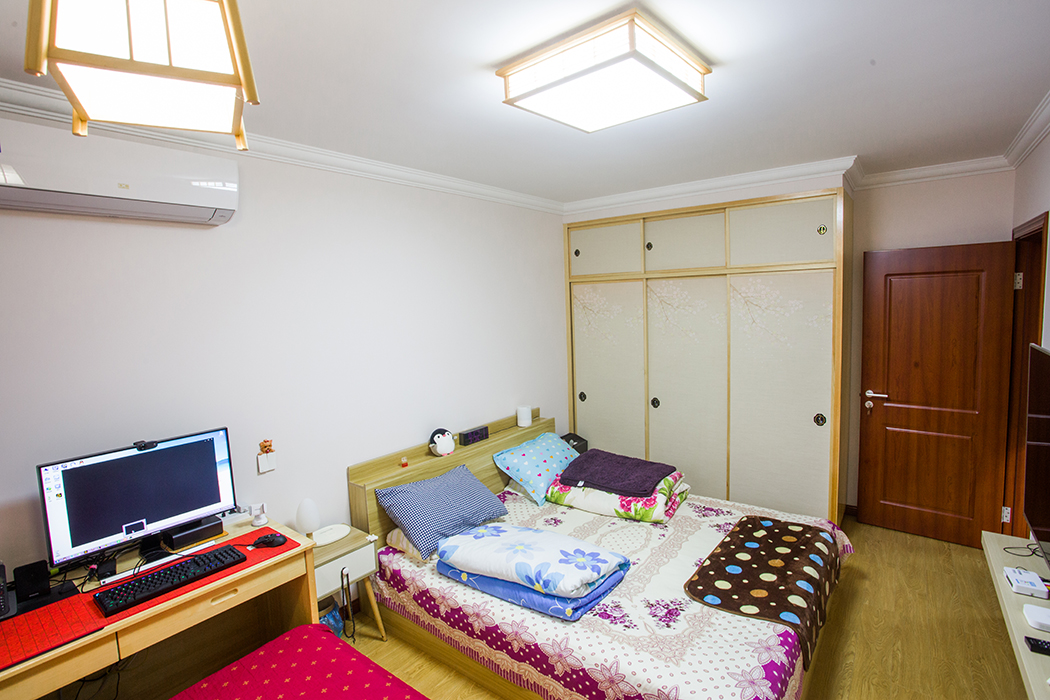 空間從色彩到材質到家具的選擇，盡顯簡約與舒適氣息。整個空間以亮色為主色調，現代的硬朗線條和咖北歐家具的組合，有種現代線條感。客廳亮色絨面沙發與粉紅靠墊、原木邊柜組合增添幾分歡快與質感。