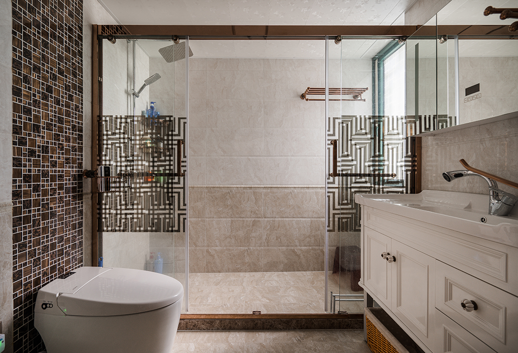 衛(wèi)生間做的干濕分離，原本外面干區(qū)做的是大儲(chǔ)物柜，客戶考慮到人比較多，便于早晚洗漱，衛(wèi)生間里面更偏現(xiàn)代，外面更注重美觀，和整體中式風(fēng)格融入一體，考慮到干區(qū)鏡子正對(duì)臥室大門(mén)，特意定制了鏡柜，美觀的同時(shí)也消除了客戶的顧慮。
