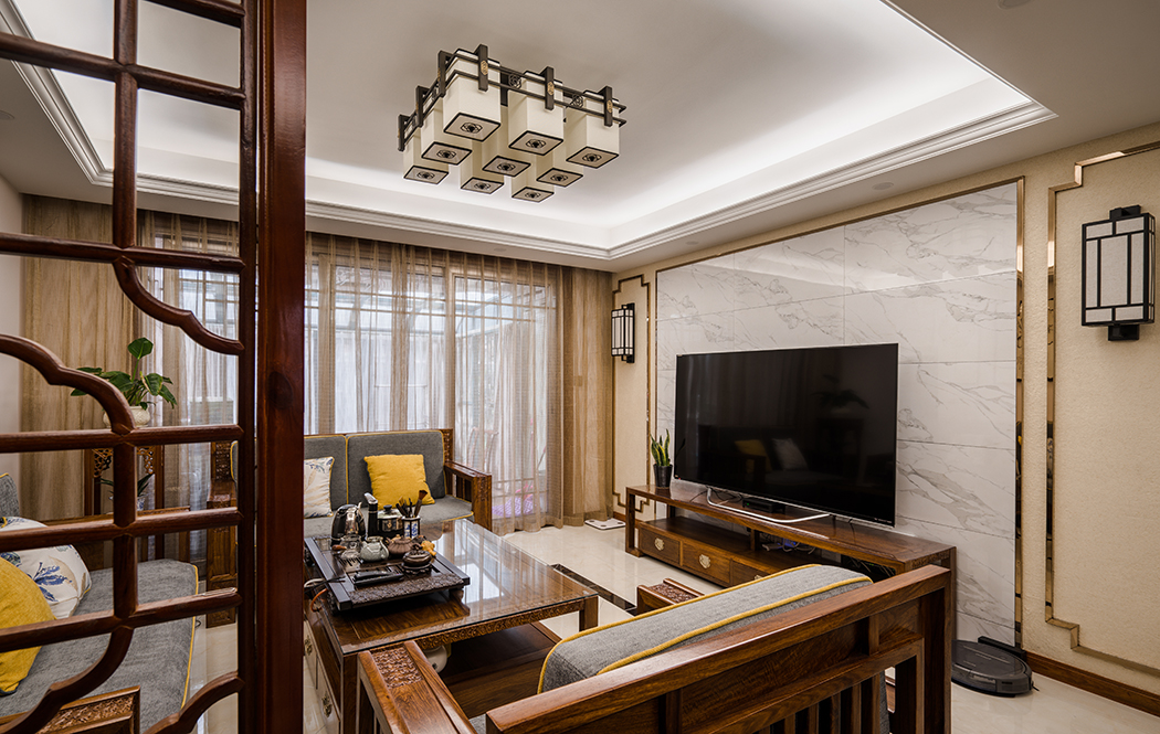 客廳整體風(fēng)格采用大理石上墻和不銹鋼線條墻衣打底，這類元素增加了現(xiàn)代感，吊頂沒(méi)做過(guò)多修飾，簡(jiǎn)單的吊頂增加了空間層次感，家具和軟裝又把我們帶入中式的元素里。
