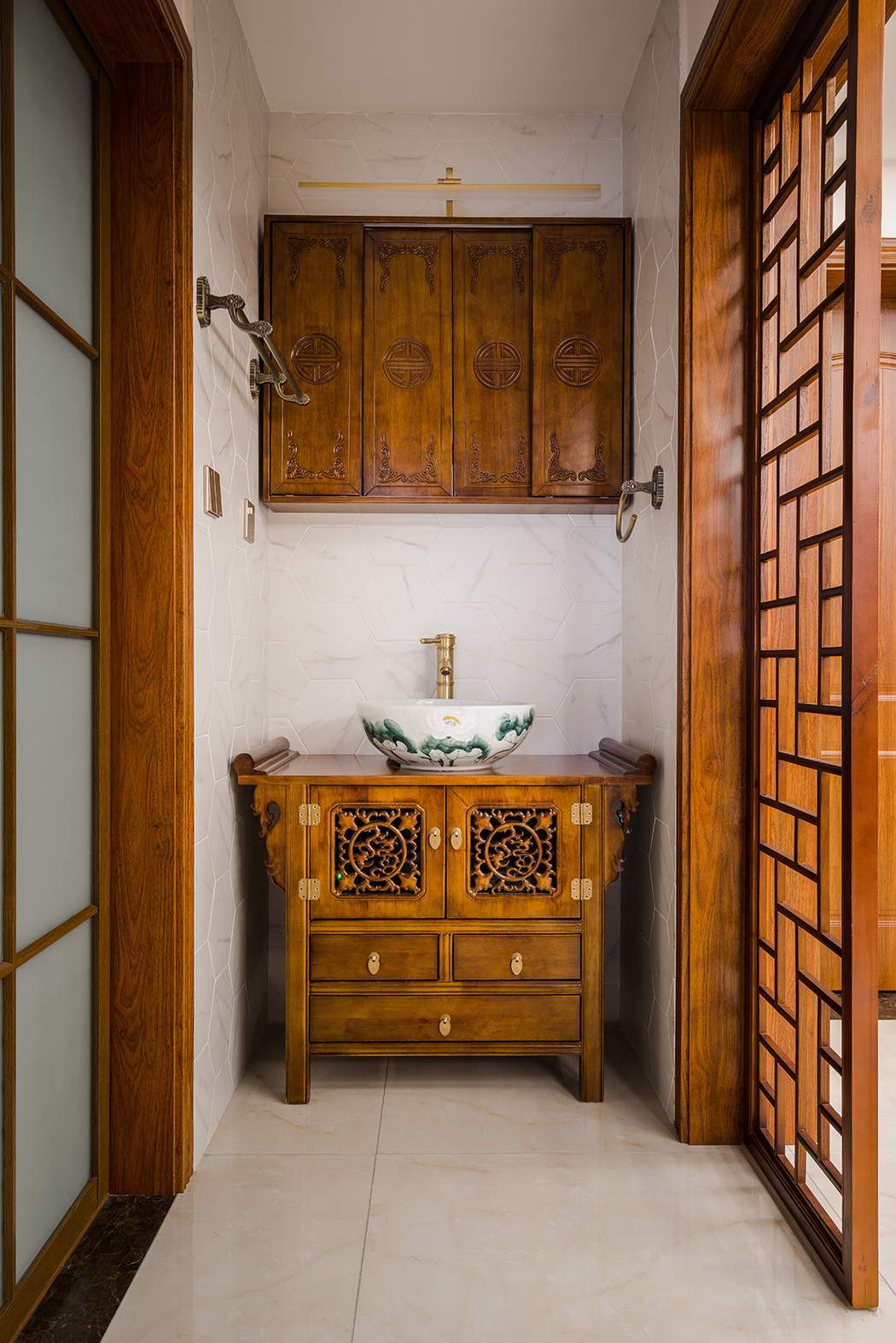 衛(wèi)生間做的干濕分離，原本外面干區(qū)做的是大儲(chǔ)物柜，客戶考慮到人比較多，便于早晚洗漱，衛(wèi)生間里面更偏現(xiàn)代，外面更注重美觀，和整體中式風(fēng)格融入一體，考慮到干區(qū)鏡子正對(duì)臥室大門(mén)，特意定制了鏡柜，美觀的同時(shí)也消除了客戶的顧慮。