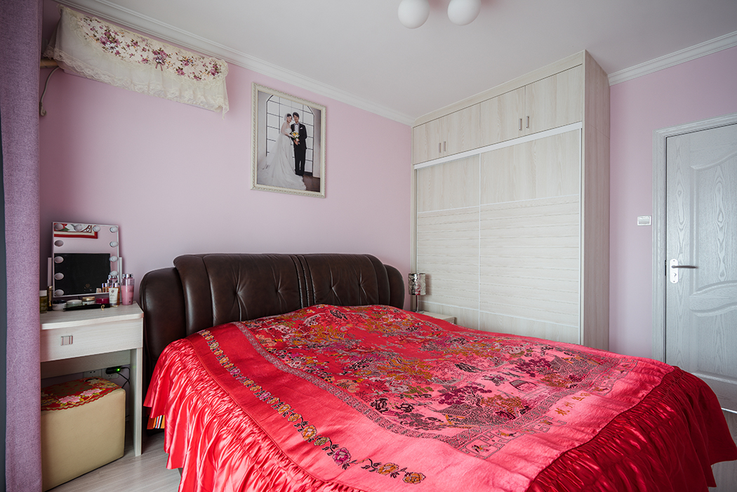 粉色的墻面暗示出了業主的少女情懷，廠價定制的大衣柜簡單切使用，大大增加了收納空間。
