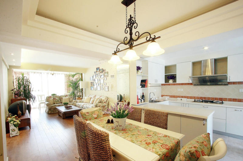 一走進室內你就會感到一股清新、自然、悠閑的田園風迎面而來。客廳小碎花沙發(fā)搭配背后的照片墻、綠植、軟裝配飾，讓客廳給人閑適的感覺，良好的采光和通風效果、餐廳、廚房開放式的設計手法避免空間狹小、壓抑的感覺，讓業(yè)主的生活環(huán)境更加的愜意。