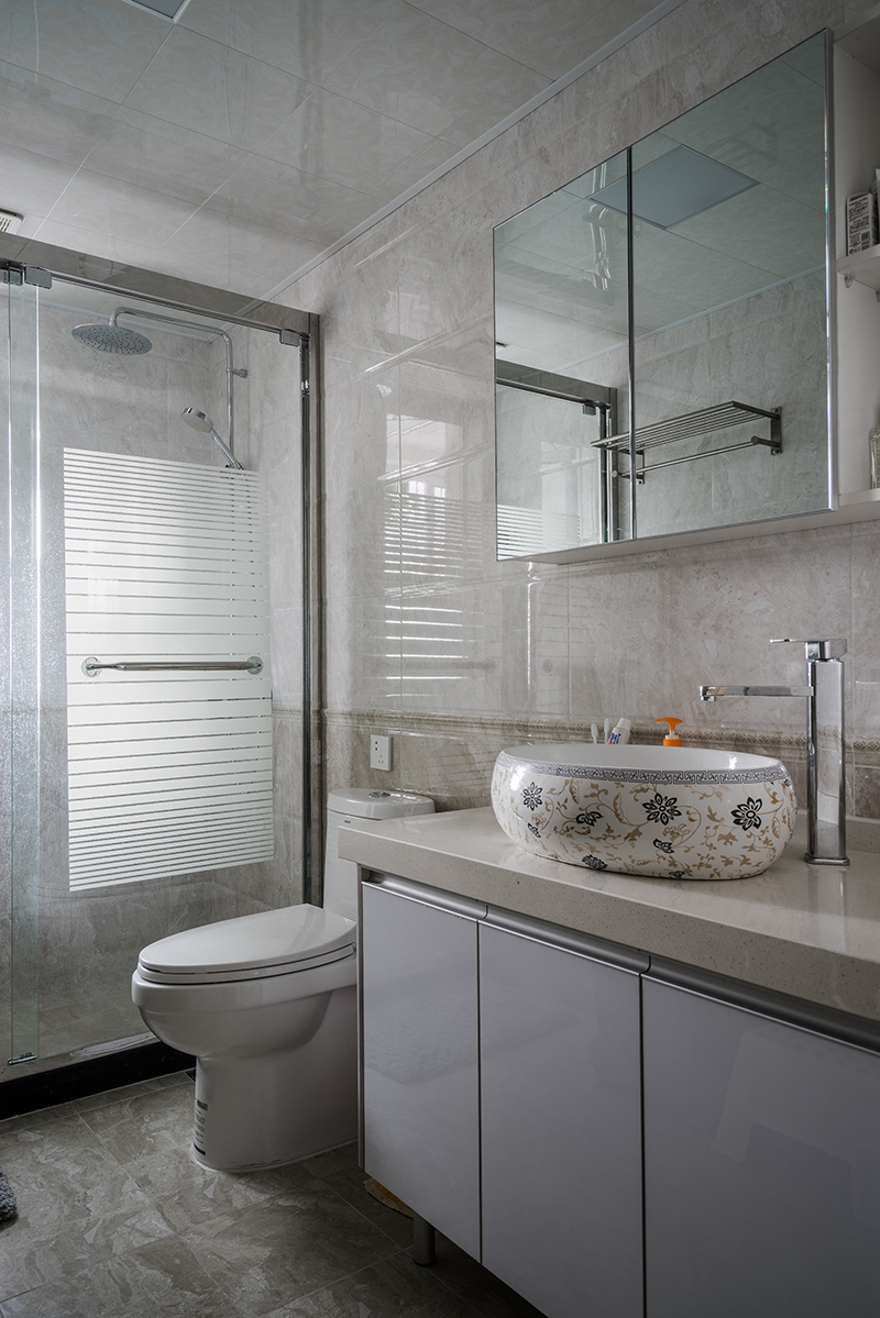 衛(wèi)生間的采光明亮，空間也適中，瓷磚用了腰帶區(qū)分了兩種顏色，簡約但是又不簡單，定制的臺盆柜和鏡柜都是按照客戶的需要量身定制，所使用的板材又是防水耐用的。
