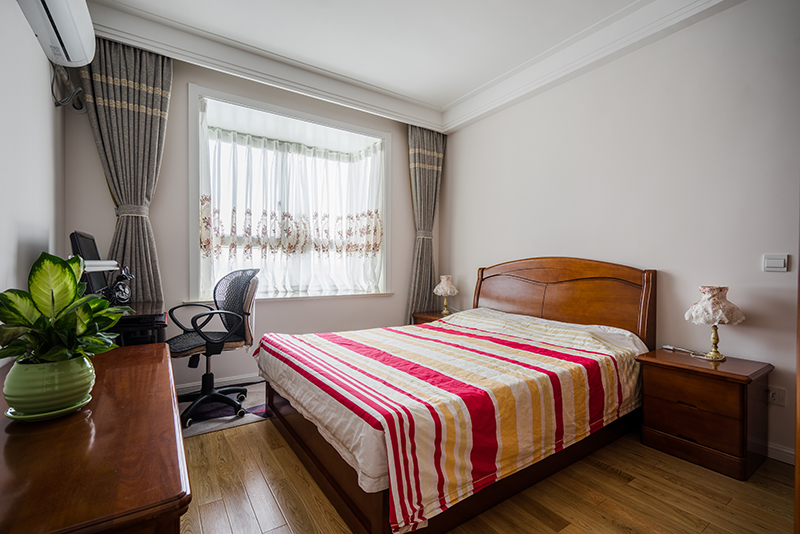   主臥室的設計延續了整個家居設計的風格，簡約大氣，又重忙時尚氣息。木紋顏色讓人感覺大自然給予人類的氣息，灰色的窗簾極其富有現代風格的代表，加上頂面吊頂的線條勾勒穿現代風格的輪廓，令人過目不忘。
