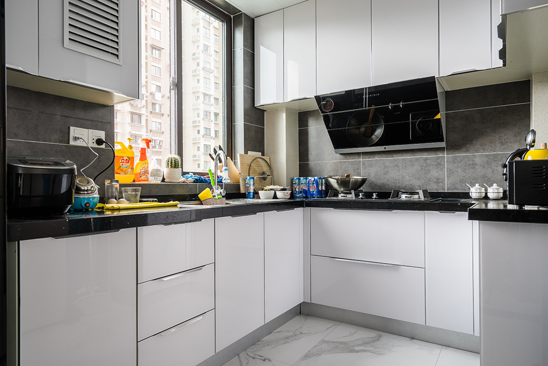 廚房空間不算小，色調以黑白灰為主，櫥柜門板特意選用金剛板，提亮空間亮度，而且方便打理，很清爽舒適。
