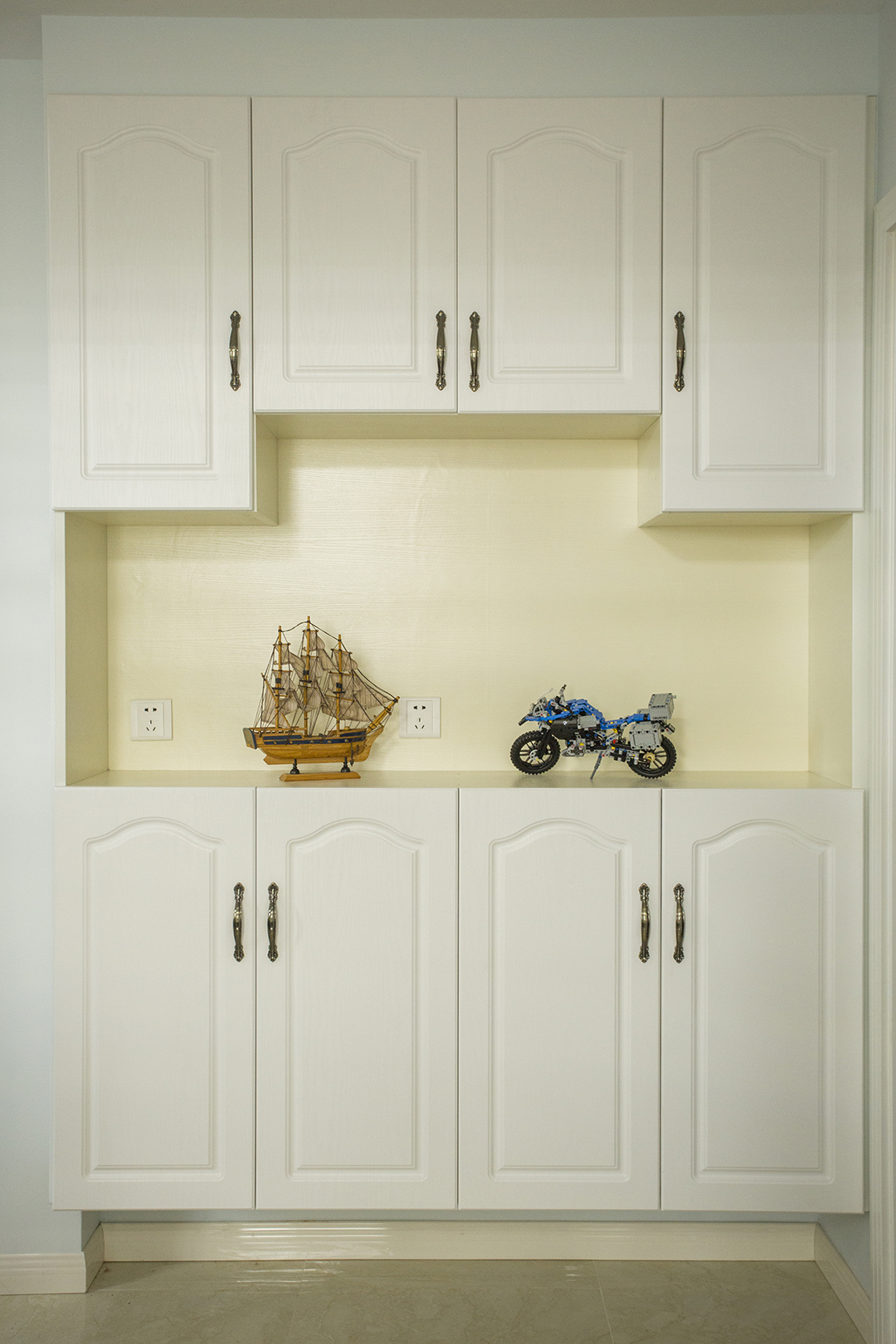 門口的鞋柜讓人一進門就被吸引住，白色模壓門板簡單大氣。底部騰空用來放拖鞋，讓辛苦一天的主人一回到家就馬上換上拖鞋，身體和神經(jīng)才能放松。中間開放部分高低錯落，方便放包和鑰匙，也能放些裝飾擺件，讓這玄關不再千篇一律。