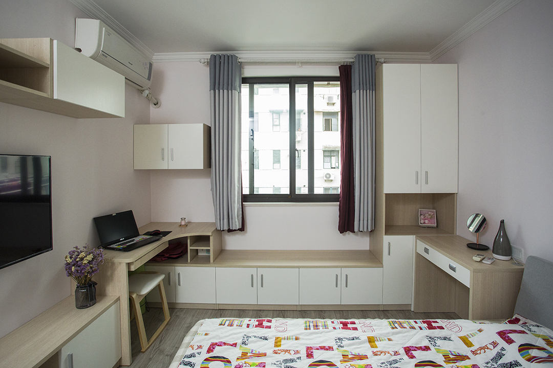 將電視柜與書桌以及窗邊休息座連為一體，在相對有限的空間內盡可能的豐富功能需求，以淺粉色作為空間的基調，輔以淺木紋、中性灰色適當點綴修飾，營造溫馨氛圍。
