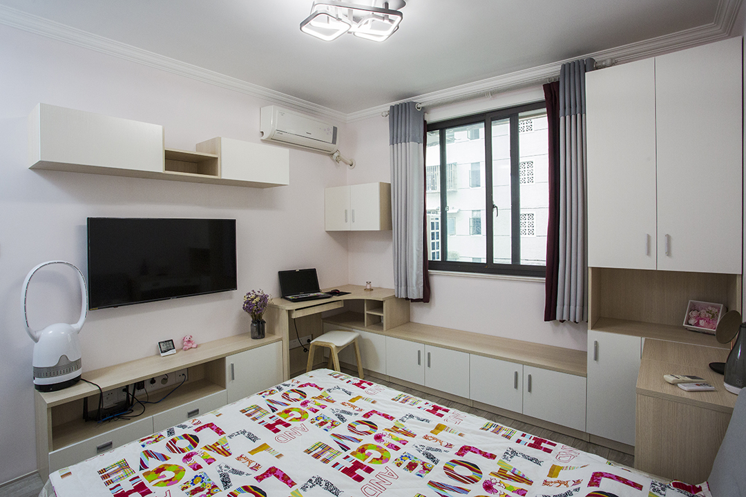 將電視柜與書桌以及窗邊休息座連為一體，在相對有限的空間內盡可能的豐富功能需求，以淺粉色作為空間的基調，輔以淺木紋、中性灰色適當點綴修飾，營造溫馨氛圍。
