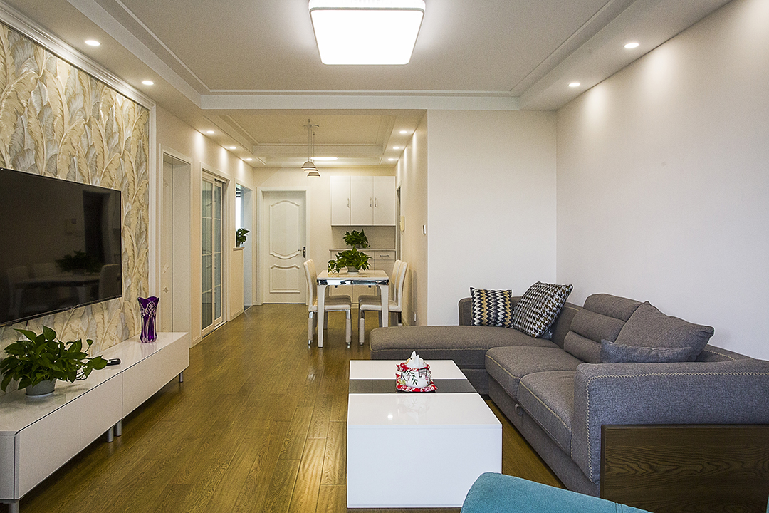客廳整體風格采用暖色涂料和諾色的地板合理搭配，電視背景墻簡單而不單調，吊頂簡約而不失簡約風格的大氣、干凈。
