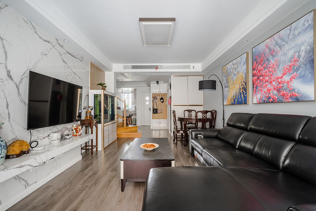 白是淺唱低吟，黑是濃情訴說，原木與石材的完美搭配，剛柔并濟，共同筑一方引人入勝心馳蕩漾的天地。色彩的魔力在于它所傳達的溫暖和釋放的感情是易被察覺與感染的，以黑白灰為主色調的客廳，使整體空間具有一種隱晦的沉穩和出其不意的恬淡美感。
