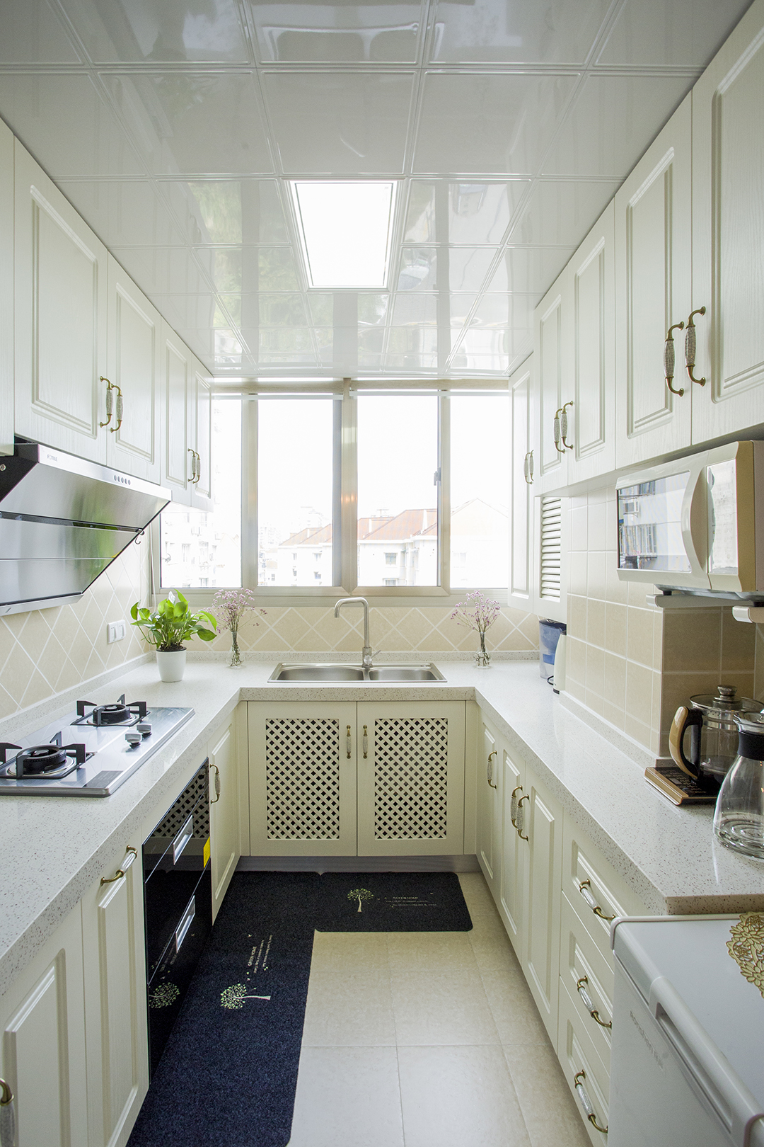 廚房間采用最簡單的歐式經(jīng)典搭配，象牙白的模壓門板，再配上淺灰色的石英石臺面，堪稱是簡歐櫥柜里的最經(jīng)典款。瓷磚在配上米黃色的小格子方磚，整體顏色和造型搭配上很和諧，讓整個效果看上去很有檔次。
