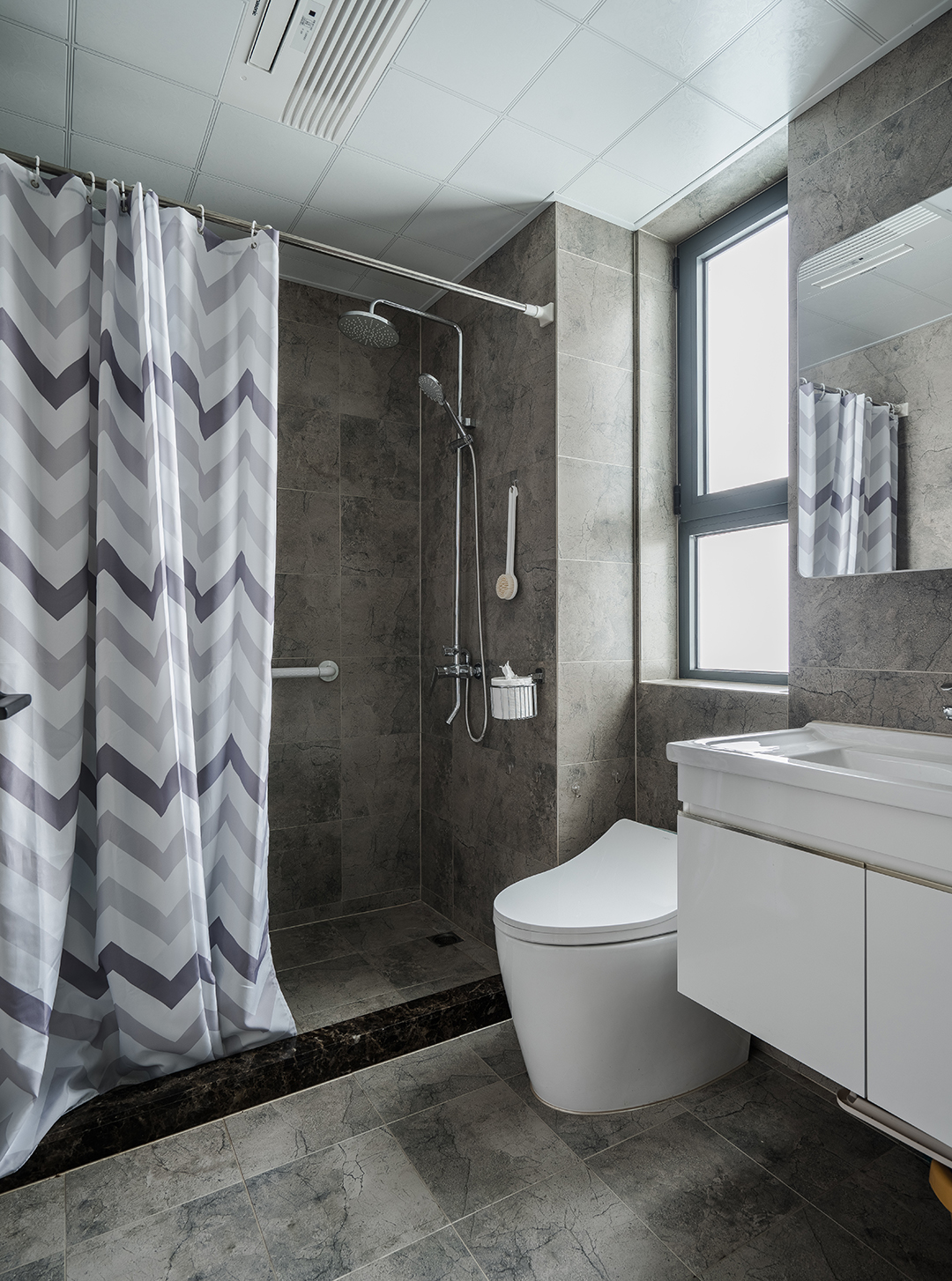 衛生間灰色的地磚上墻，白色的衛生潔具，給人不一樣的視覺效果。
