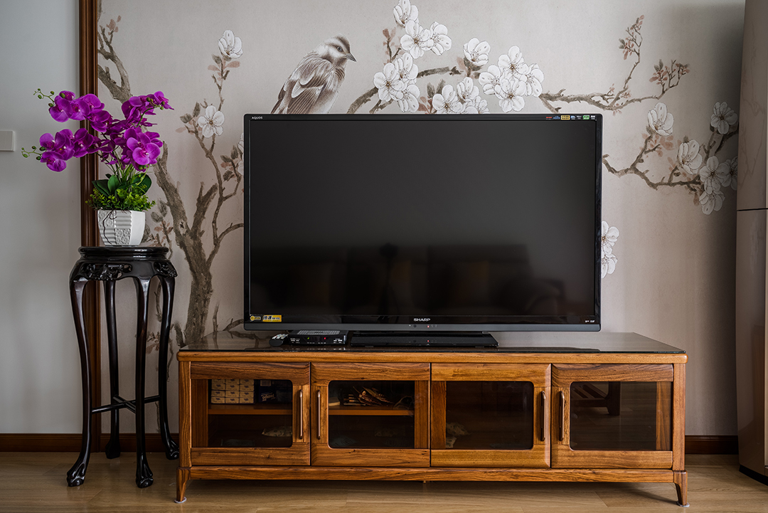 客廳整體風格采用木線條風格，是當下比較時尚也是板式的處理方式，在顏色上做了統一，配上精致的3D立體壁布，把板式的硬線條做了軟性富有穩重。