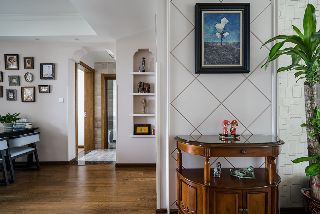 玄關背景采用最簡單的石膏板勾縫處理，利用過道的空間做出簡單的石膏門洞，提升整體的弧度。
