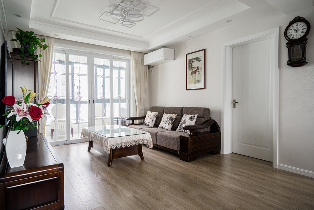 客廳簡(jiǎn)潔的線條與米色的墻面，地面凝結(jié)成暖調(diào)，營(yíng)造了一片溫馨；實(shí)木家具與墻面以強(qiáng)烈的色彩，陳設(shè)出家的自在和品質(zhì)。
