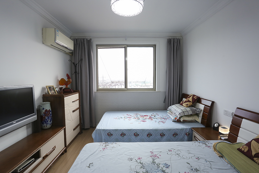  偶爾會(huì)有孩子過(guò)來(lái)居住，故臥室擺放兩張床，簡(jiǎn)潔的石膏線條，木紋豐富的地板，衣柜、電視柜及床的整體搭配，大大提升了空間都整體感。