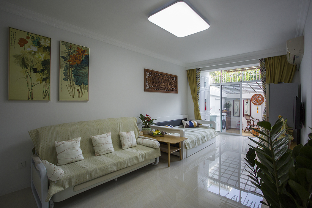 客廳整體風格采用中式木雕、中式畫作為點綴，在現代風格里做了一個美好的點綴，在顏色上做了統一，配上精致的玻璃燈的裝飾及綠色植物的配飾，讓空間更具有生命活力。
