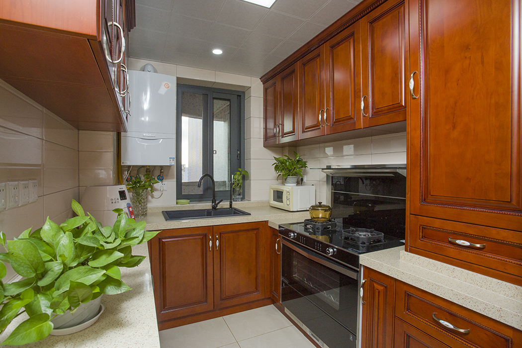 廚房是女主人的戰場，在選材上也比較考究。選用了實木材料定做，臺面配以暖黃色石英石。和客廳紅木家具以及整體風格互相呼應。
