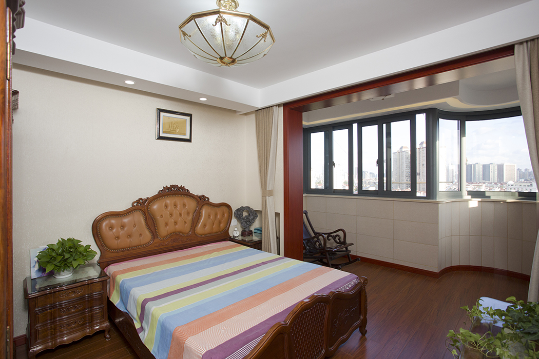 主臥室用精致的彩色布藝點綴其間，打破了空間用色的平淡，將自身蘊含的熱情充分展示出來。內部環境以暖色墻面和深色地板主角，淡雅的窗簾散發著雅致的氣質。家具錯落有致的擺設，在燈光的勾勒下，顯示出清晰的輪廓。
