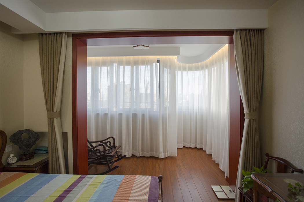 主臥室用精致的彩色布藝點綴其間，打破了空間用色的平淡，將自身蘊含的熱情充分展示出來。內部環境以暖色墻面和深色地板主角，淡雅的窗簾散發著雅致的氣質。家具錯落有致的擺設，在燈光的勾勒下，顯示出清晰的輪廓。
