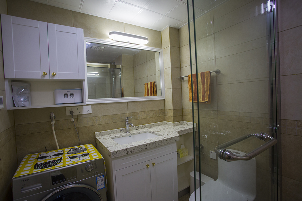 衛生間采用暖色上下分開的搭配瓷磚，白色基底花色臺面加以白色柜門，使得整個空間非常的融合，給人一種溫暖的感覺，既時尚又大氣。
