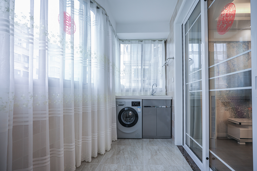 陽臺暗藏式窗簾盒完美的體現了房屋結構的曲線美，暗藏式儲物柜加上整體洗衣柜作為功能陽臺，滿足了業主日常的洗衣儲物功能!
