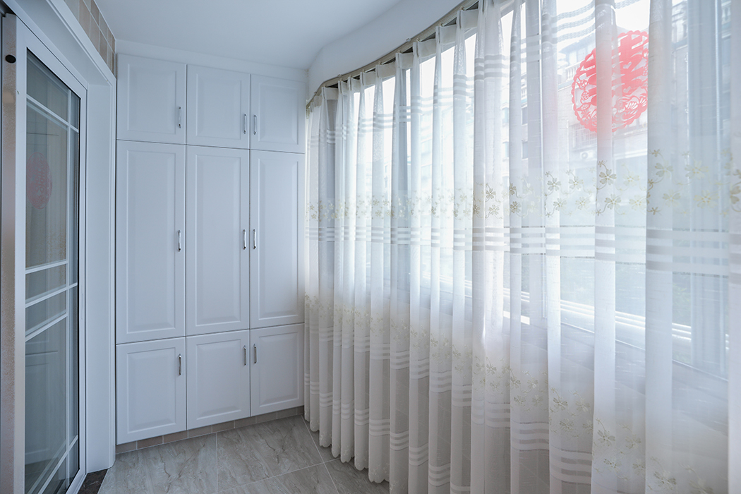 陽臺暗藏式窗簾盒完美的體現了房屋結構的曲線美，暗藏式儲物柜加上整體洗衣柜作為功能陽臺，滿足了業主日常的洗衣儲物功能!
