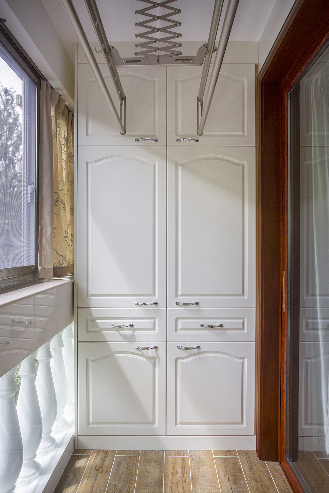 小小的陽臺設(shè)計別出心裁。首先設(shè)計上，上面晾曬衣服，旁邊有以收納為主的櫥柜，有著簡化的線條，自然的材質(zhì)。