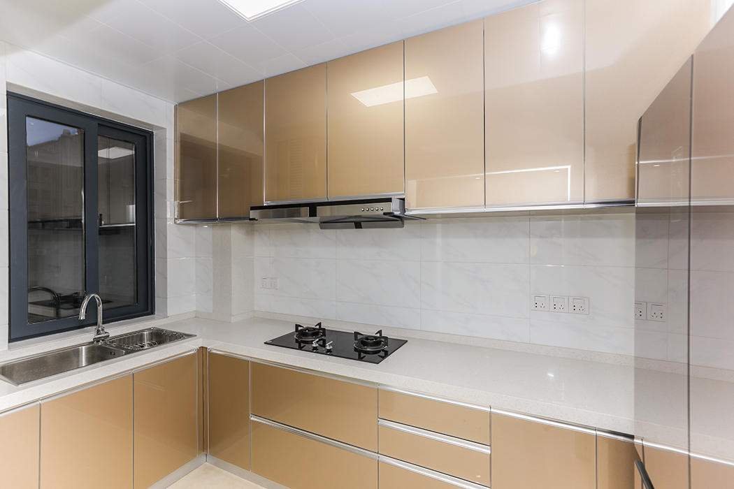 廚房是準備食物并進行烹飪的房間，操作和儲物空間盡量大，顏色要簡潔明快，材質要干凈和好打理，白色的鋁合金集成扣板、白色帶淺藍紋理的墻相呼應，珠光金的櫥柜門板、玫瑰金色的雙門冰箱相協調。給人干凈、清爽、大氣華貴的感覺。
