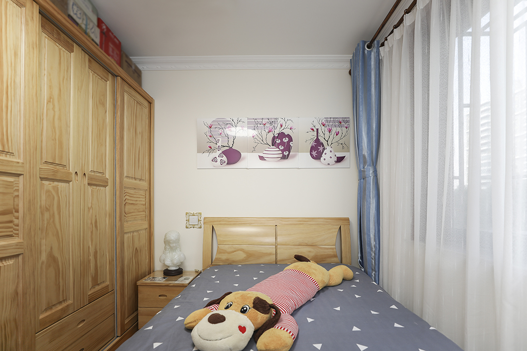 次臥的墻面顏色的設計主要根據客戶家兒子的設計要求選定的，使用了原木色的整體家居，讓整個中式不在沉重單調。
