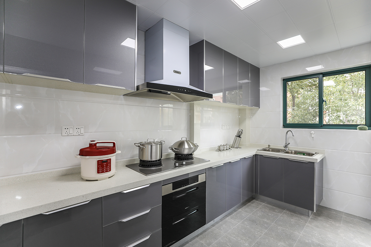 廚房區，因為業主喜好做美食，使用頻率較高，所以選了亮晶灰色門板，容易擦洗打理，素色墻磚，讓空間變得更加純粹
