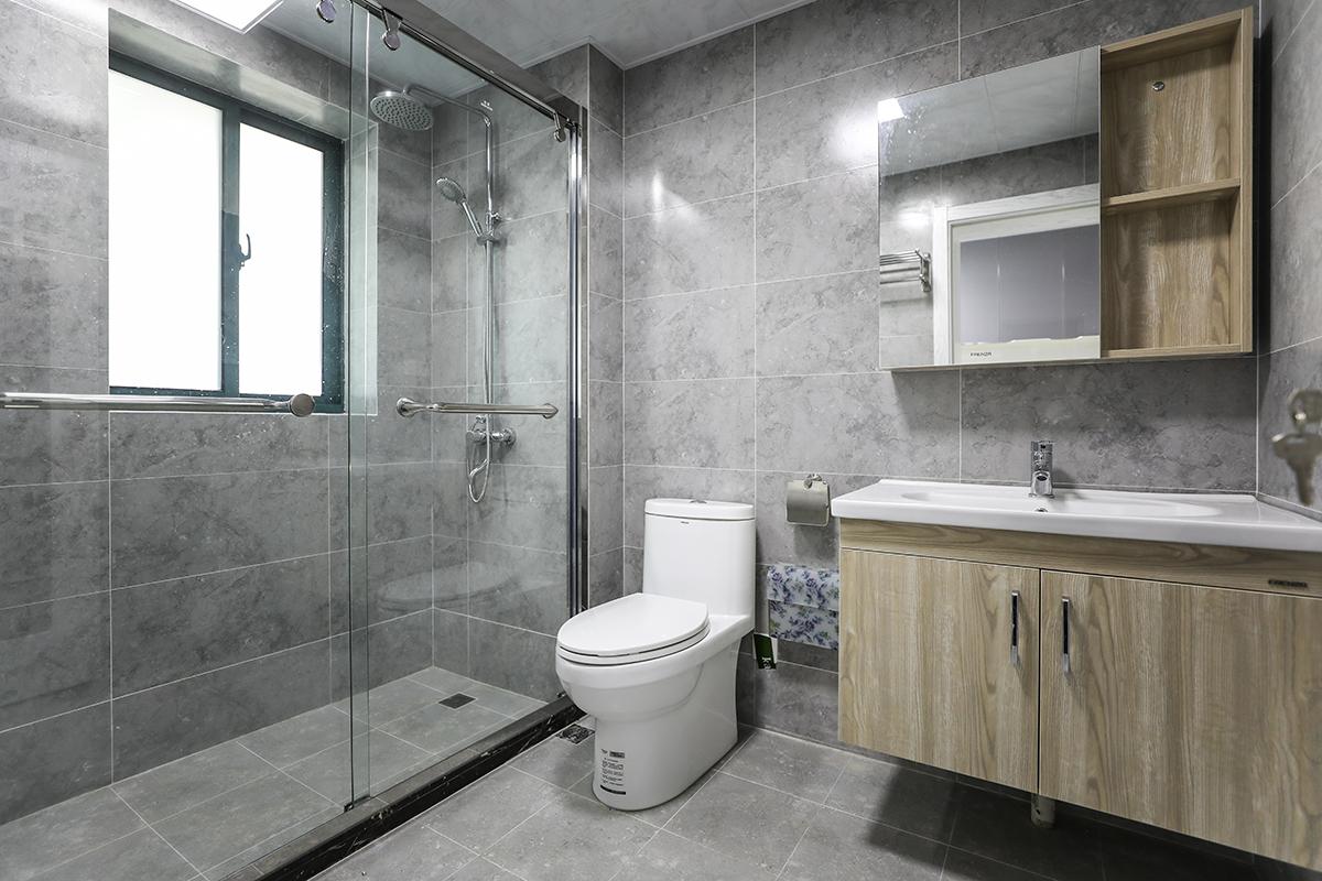 衛生間，采用水泥質感的瓷磚搭配掛墻木紋色臺盆柜，地道的北歐風，一切是那么的協調，也方便打掃衛生。