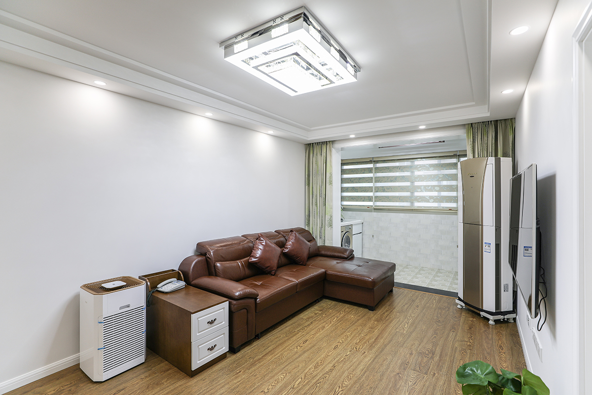 客廳整體風格采用灰色墻面涂料和灰色木紋系的地板合理搭配，沙發采用以皮色棕色為基礎的色彩搭配，使得整體空間的延伸，吊頂采用臺階式吊頂加以簡單線條，配以中性色的射燈，使得光線得以明朗，視覺得以解放。
