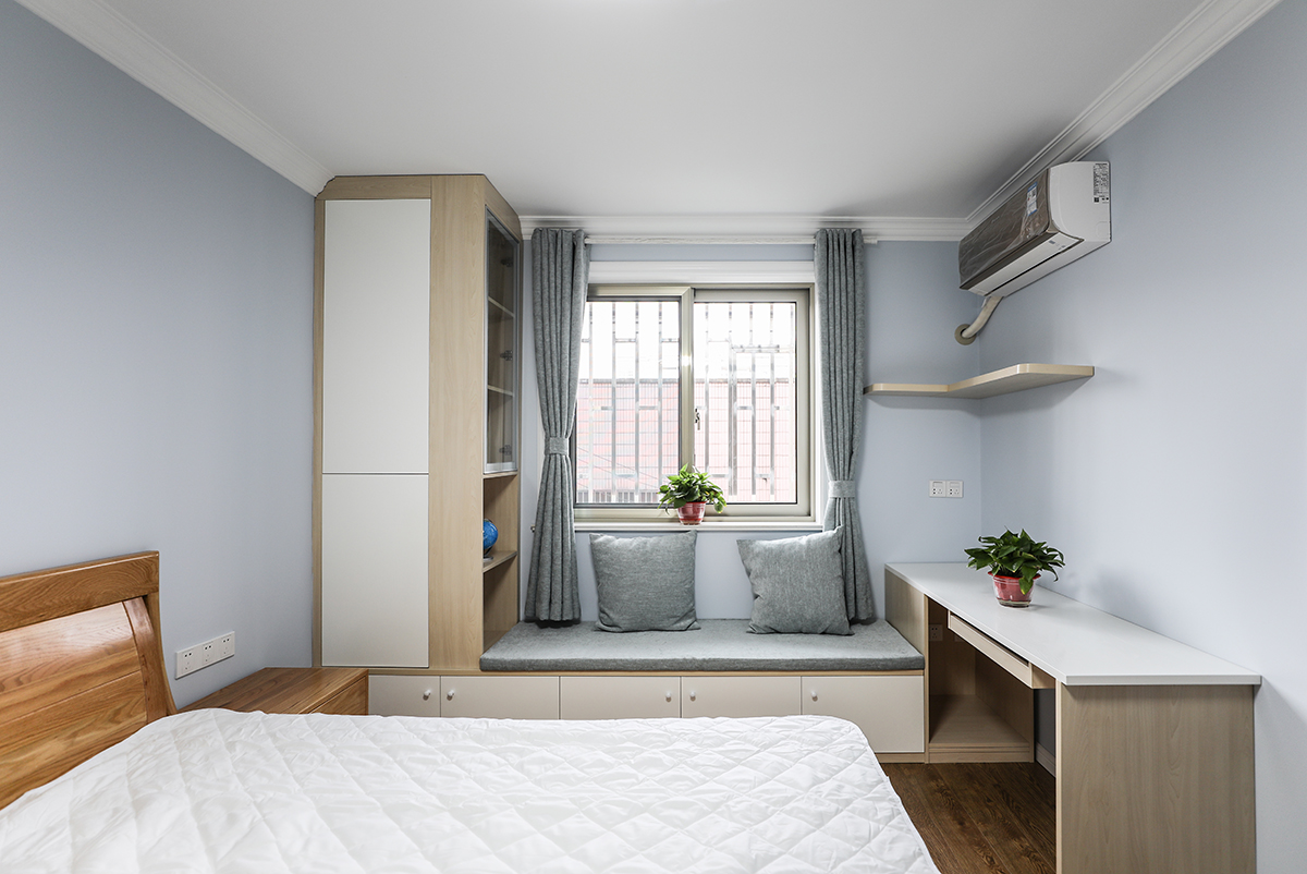 主臥室采用原木色的窗體加以咖色的窗簾使得本身單調的色彩空間立馬體現出色彩的多樣話和柔和度，使得整體色彩非常的舒服，給人以非常舒服的休息環境，白的的家具使得色彩反差非常的大，立體效果非常的舒服，體現業主的追求極簡自由的生活。
