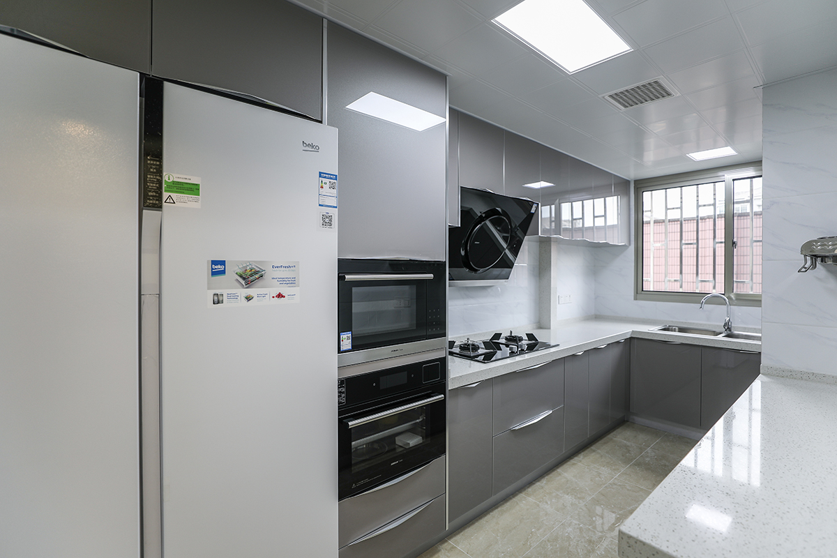 廚房采用灰色色系，充分體現簡約風格，側吸的煙機，白色臺面和灰色櫥柜的合理搭配，顯現出客戶的整潔生活，灰色和白色瓷磚的搭配更加的合理大氣，隨著家庭電器的不斷增加使得廚房在設計上對于電器的需求充分合理的安排。
