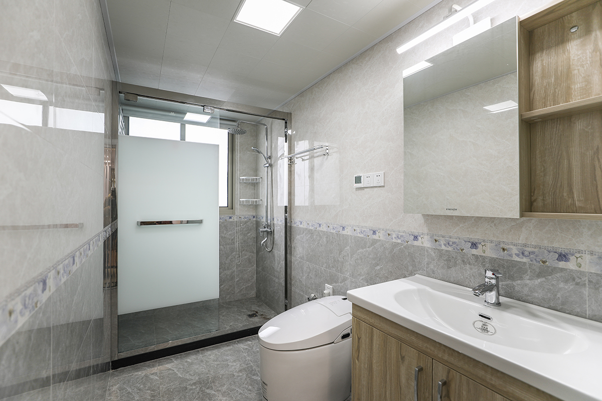 這個衛生間整體格局非常的不錯，所以在墻面瓷磚上的運用采用了上磚+腰帶+下磚的風格搭配，主要以灰色系為主，配以紫羅蘭的腰帶色彩，使得整體的色彩非常的舒適協調。
